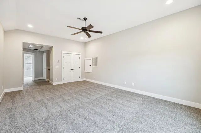 an empty room with closet and a ceiling fan