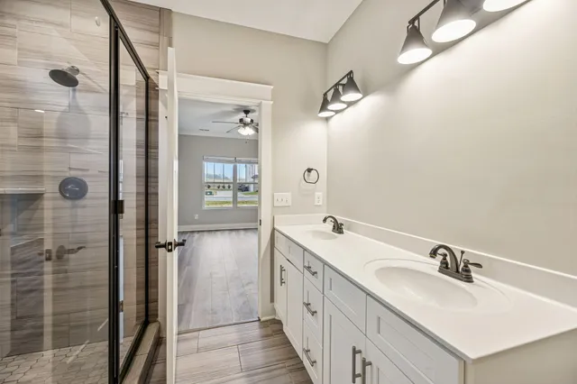 a bathroom with a double vanity sink a mirror and shower
