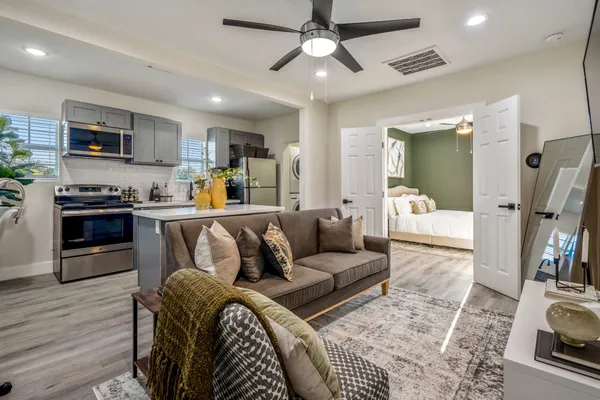 a living room with furniture and a wooden floor
