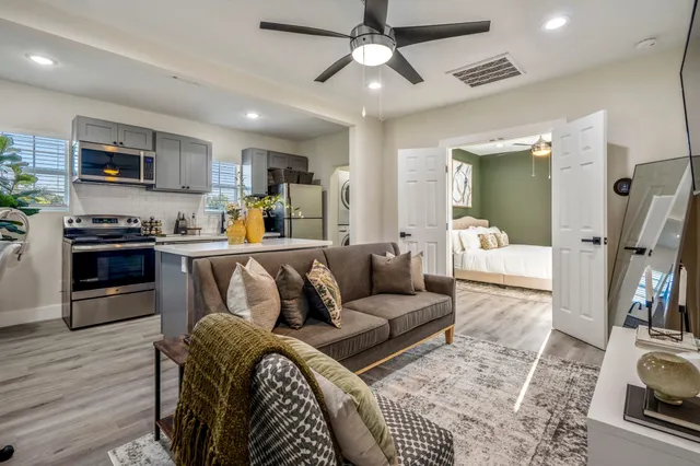 a living room with furniture and a wooden floor