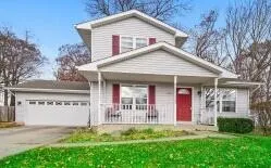 a view of a white house with a yard and plants