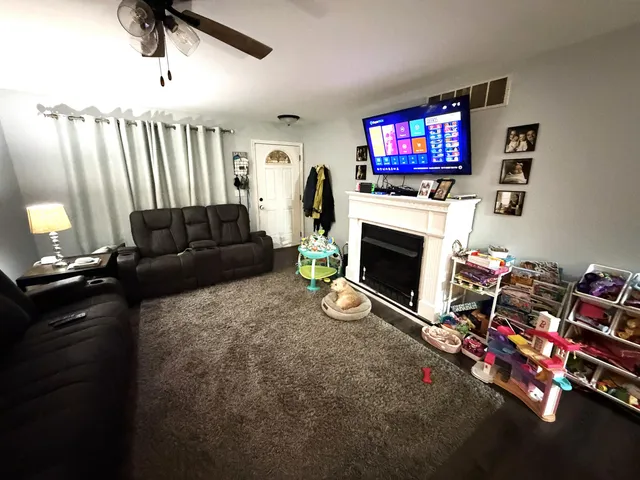 a living room with furniture a flat screen tv and a fireplace