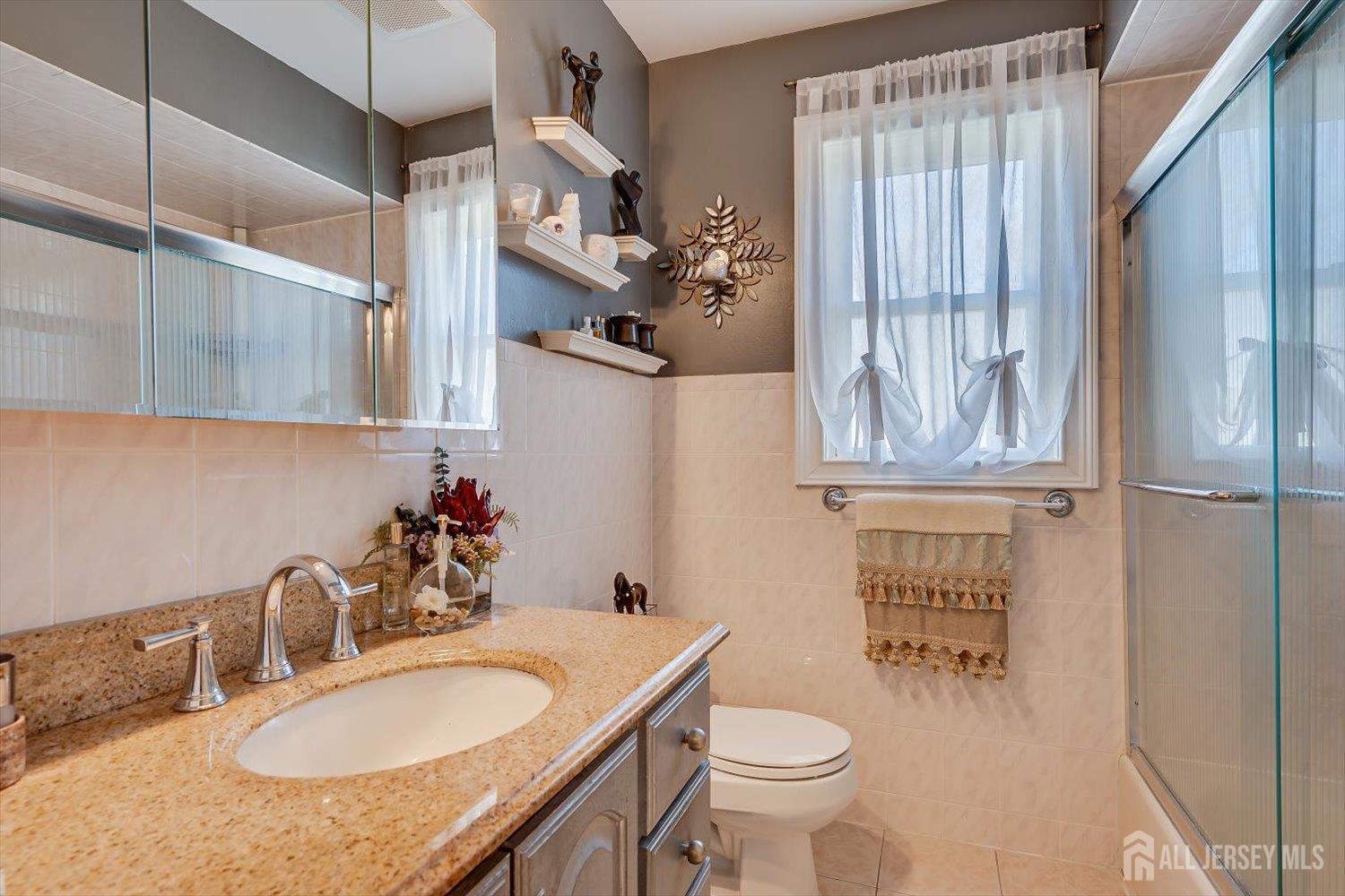 71 Crosby Avenue Edison, NJ 08817 - Photo 19 of 40 a bathroom with a granite countertop sink a toilet a mirror and shower