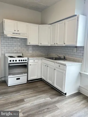 a kitchen with granite countertop white cabinets and white appliances
