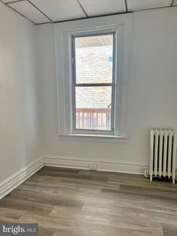 a view of a room with wooden floor and a window