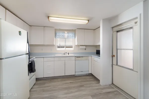 a kitchen with white cabinets and white appliances