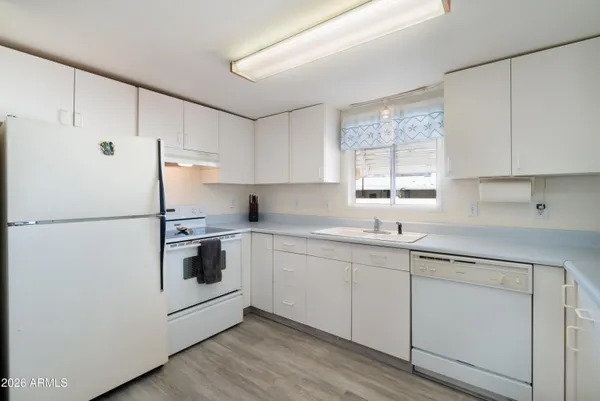 a kitchen with stainless steel appliances a refrigerator stove microwave and wooden floor