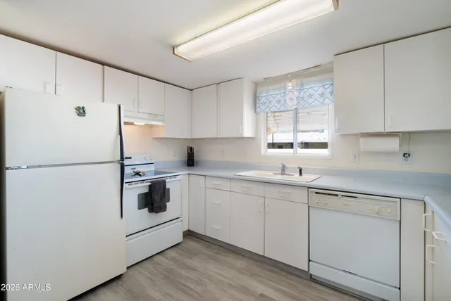 a kitchen with stainless steel appliances a refrigerator stove microwave and wooden floor