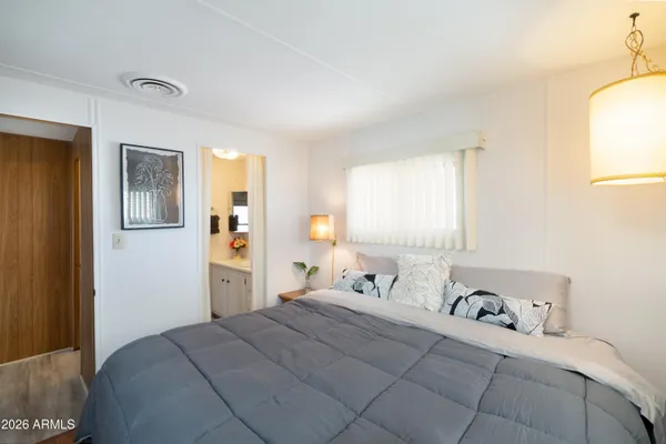 a bedroom with a bed and wooden floor