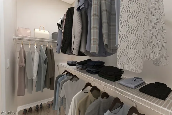a view of walk in closet with clothes and shoes