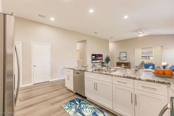 a kitchen with white cabinets and sink