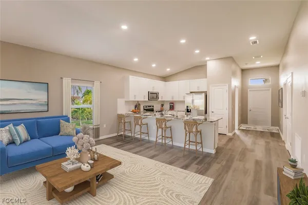 a living room with furniture and view of kitchen