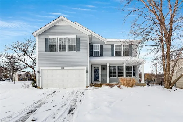 a front view of a house with a yard covered in snow
