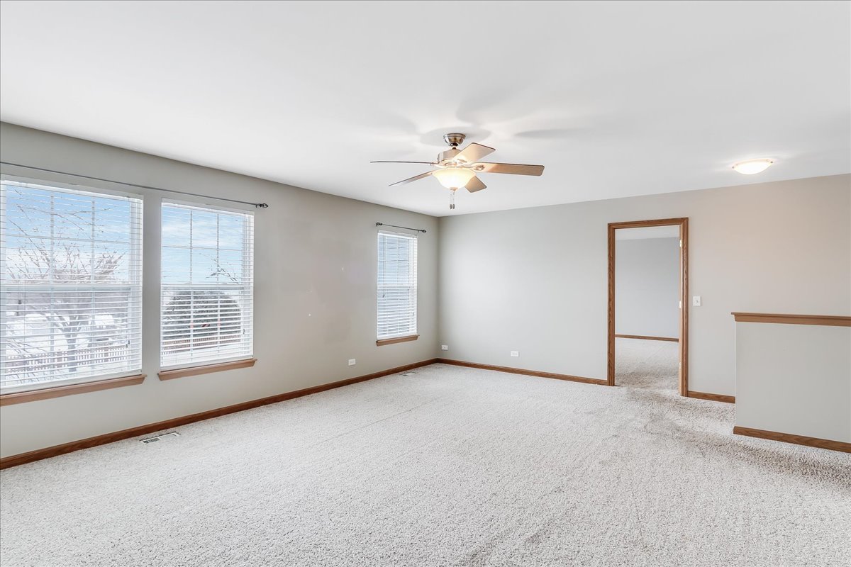 600 Spring Drive Marengo, IL 60152 - Photo 14 of 28 an empty room with windows and chandelier fan