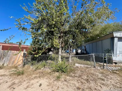 a view of backyard with wooden fence and large trees