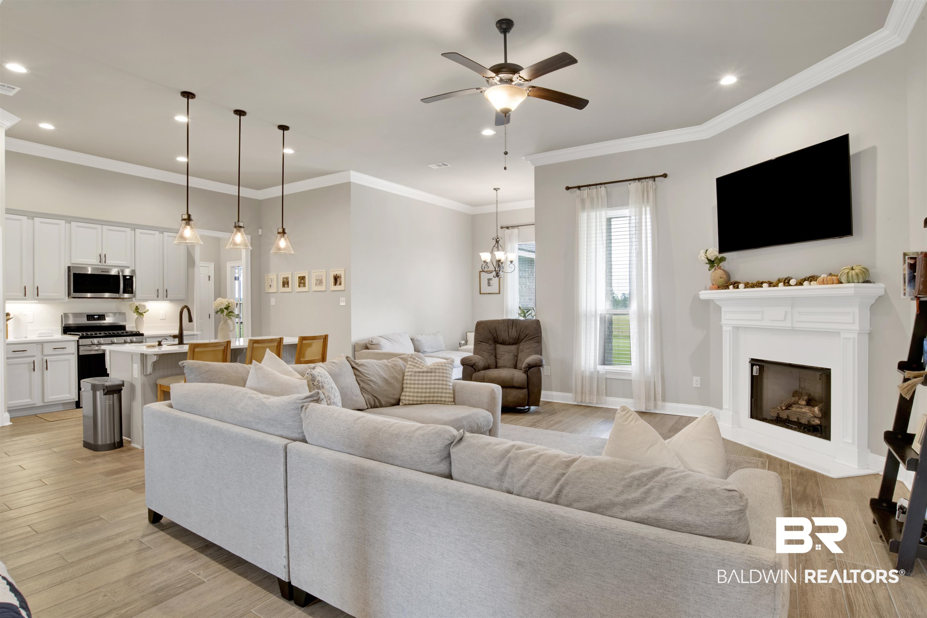 30770 Marcel Boulevard Spanish Fort, AL 36527 - Photo 4 of 23 Living room featuring ornamental molding, ceiling fan with notable chandelier, and light hardwood / wood-style floors
