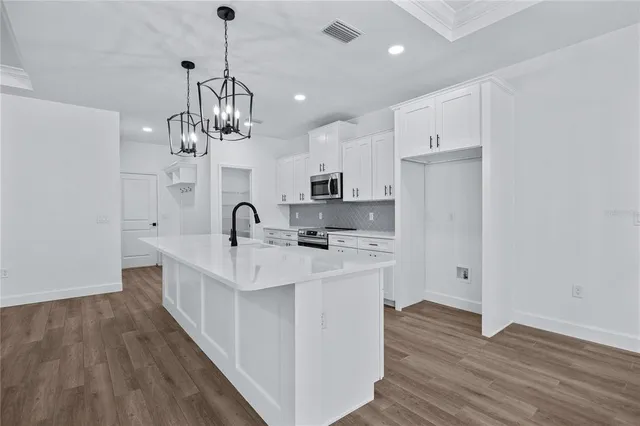 a large kitchen with sink and cabinets