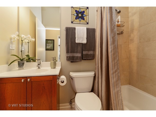 2089 West Wabansia Avenue, Unit 306 Chicago, IL 60647 - Photo 11 of 12 a bathroom with a toilet sink a shower and a mirror