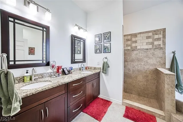 a bathroom with a granite countertop sink a mirror a vanity and shower