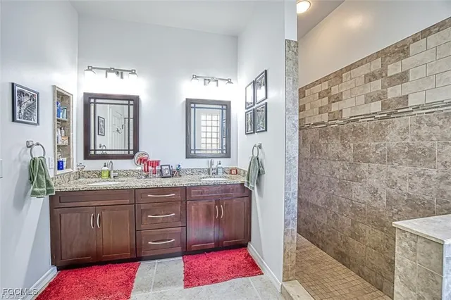 a bathroom with a granite countertop sink a mirror and a shower