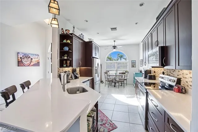 a kitchen with stainless steel appliances a table chairs and a refrigerator