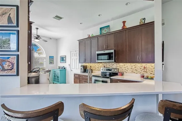 a living room with stainless steel appliances kitchen island granite countertop furniture and a fireplace