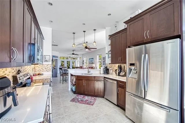 a kitchen with stainless steel appliances granite countertop a refrigerator a sink a stove and a refrigerator