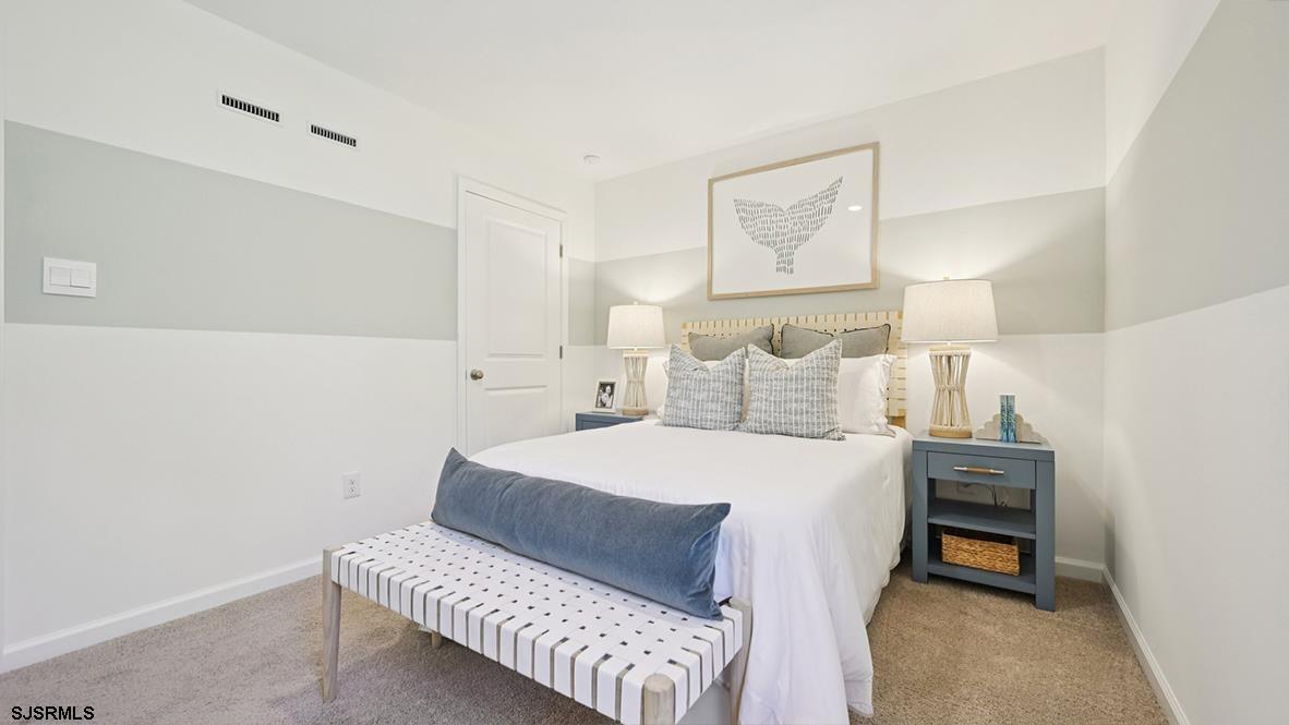 504 Scotty Boulevard, Unit 1203 Rio Grande, NJ 08242 - Photo 26 of 40 a bedroom with a bed and a lamp