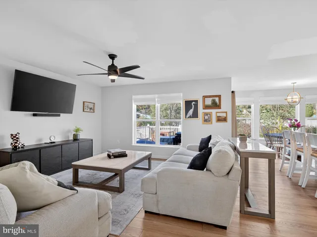 a living room with furniture a flat screen tv and a refrigerator