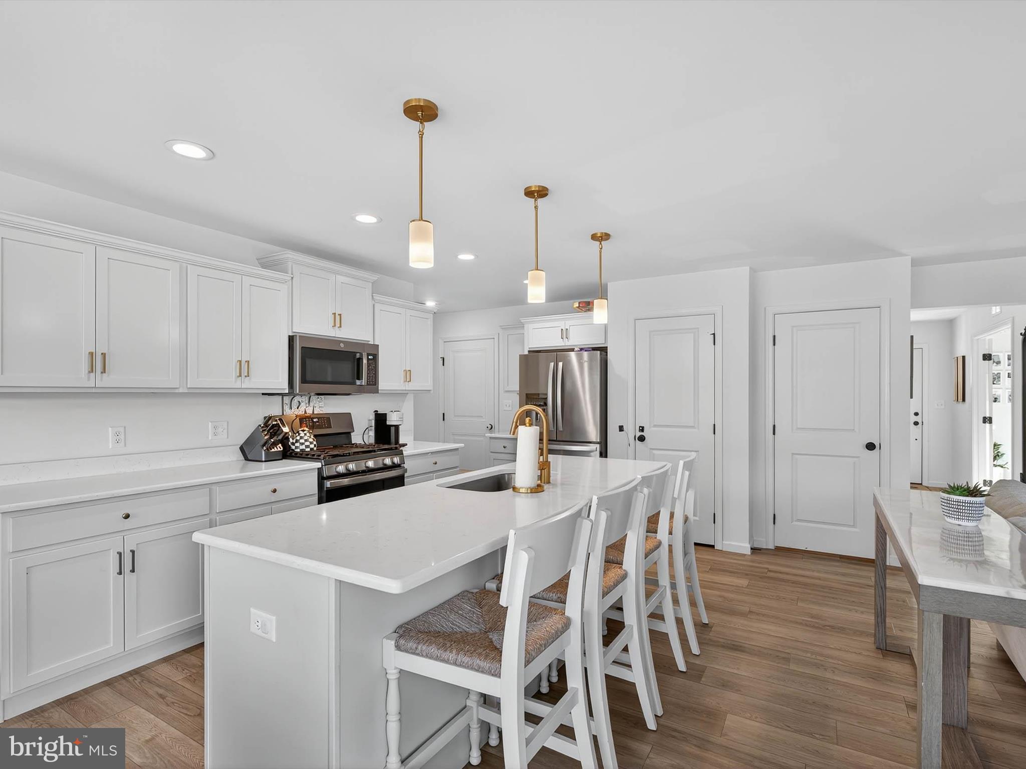 29 Ladderback Lane Reading, PA 19606 - Photo 17 of 60 a kitchen with stainless steel appliances a stove a sink a refrigerator a microwave oven a dining table and chairs with wooden floor