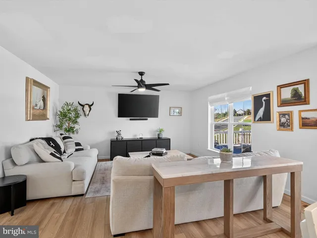 a kitchen with stainless steel appliances kitchen island granite countertop a sink a stove a dining table chairs and white cabinets