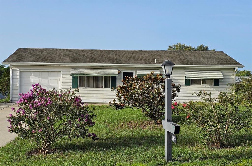 front view of house with a yard and potted plants