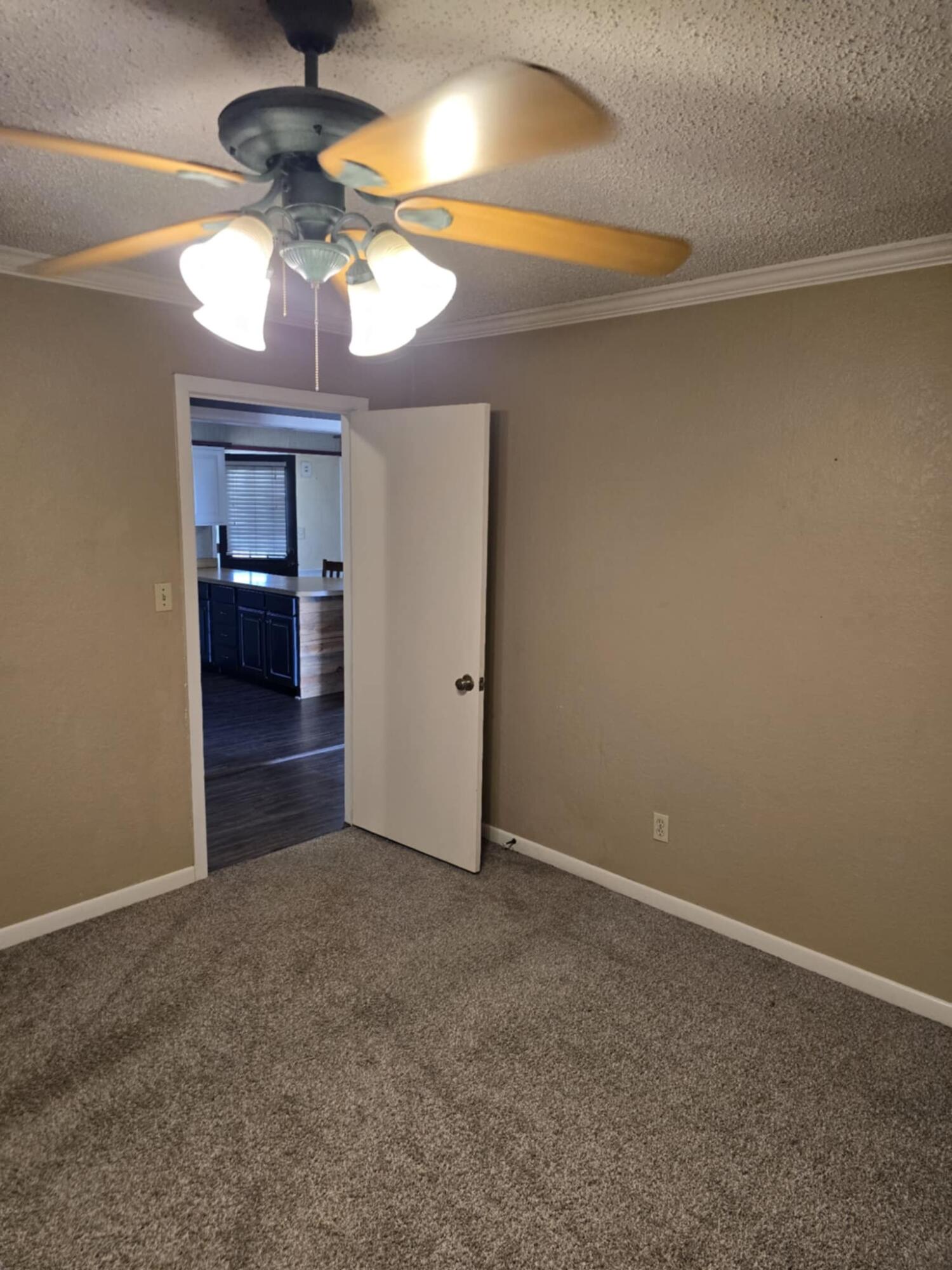 640 Fm 168 Olton, TX 79064 - Photo 10 of 30 an empty room with a chandelier fan and windows