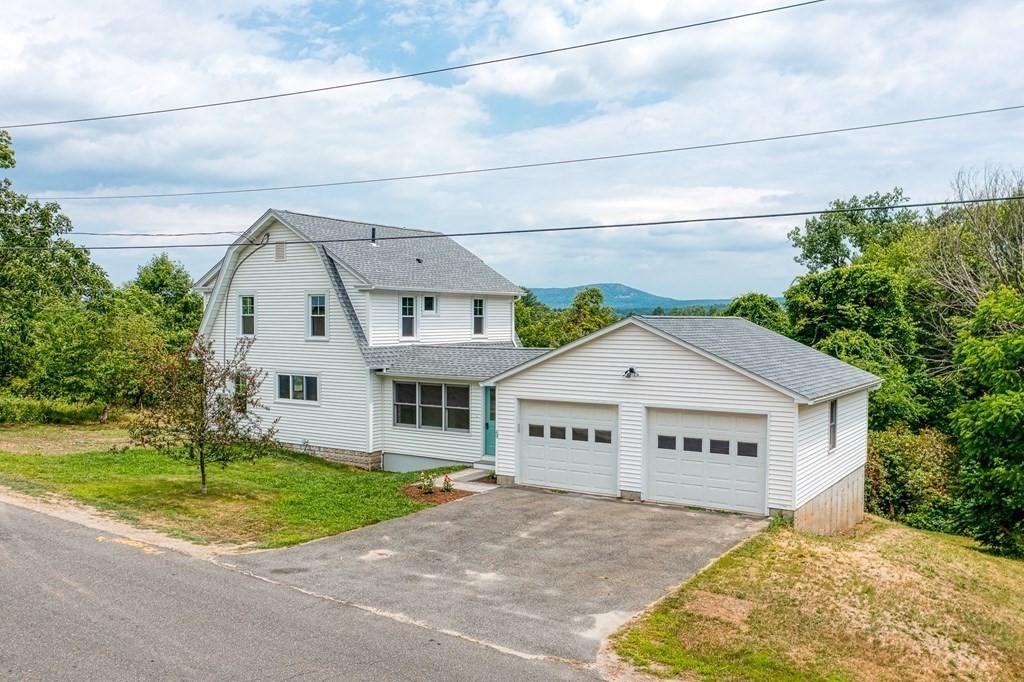 a view of house with yard and tree in front of it