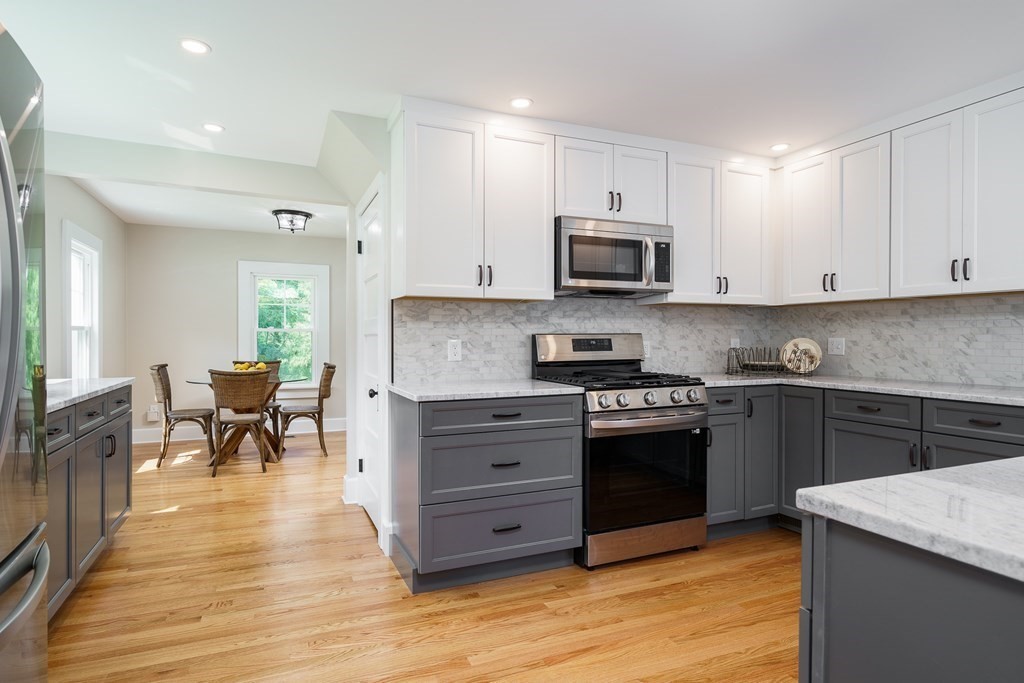 69 High Street Southampton, MA 01073 - Photo 11 of 42 a kitchen with stainless steel appliances granite countertop a stove top oven a sink a dining table and chairs with wooden floor
