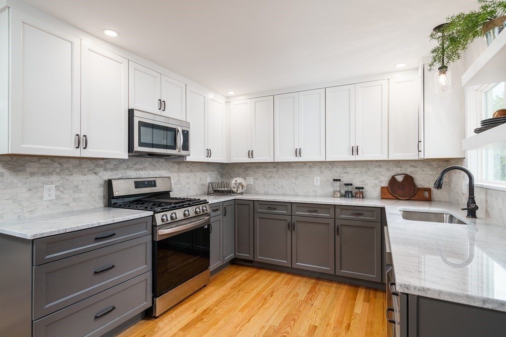 69 High Street Southampton, MA 01073 - Photo 12 of 42 a kitchen with stainless steel appliances granite countertop a stove a sink dishwasher and a microwave oven with white cabinets
