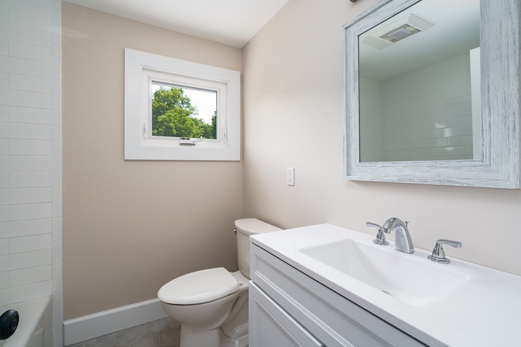 69 High Street Southampton, MA 01073 - Photo 36 of 42 a bathroom with a granite countertop toilet a sink and mirror