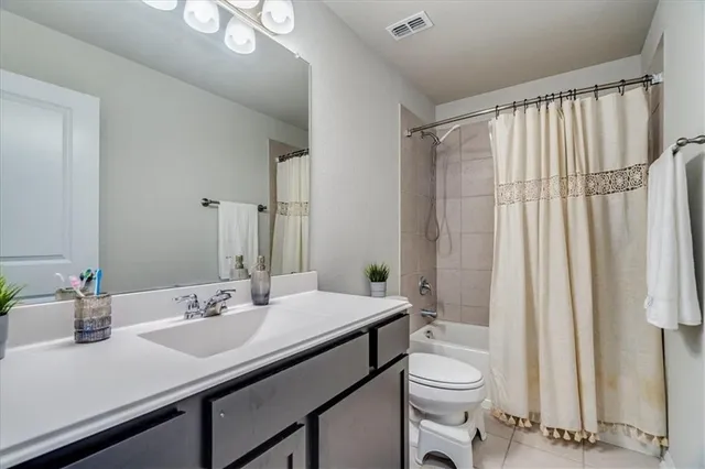 a bathroom with a sink a toilet and shower curtain