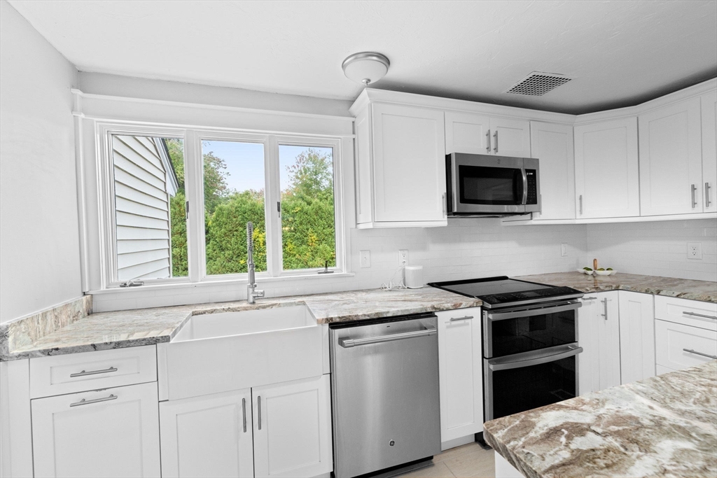 983 Webster Street Hanover, MA 02339 - Photo 14 of 41 a kitchen with granite countertop a stove sink and microwave