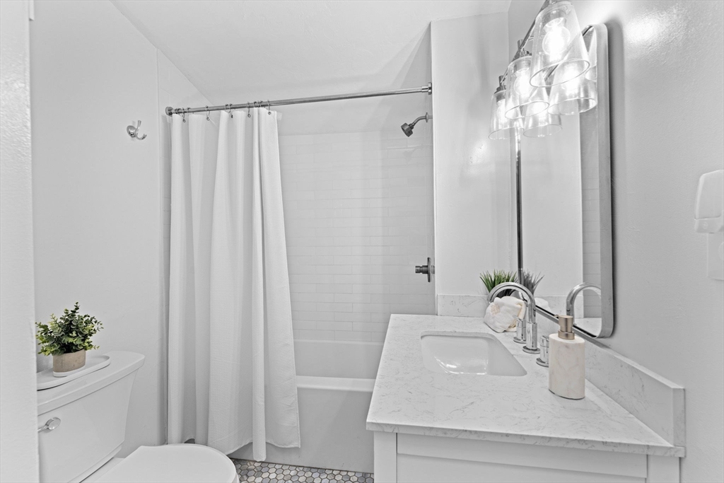 983 Webster Street Hanover, MA 02339 - Photo 23 of 41 a bathroom with a sink a toilet and shower curtain