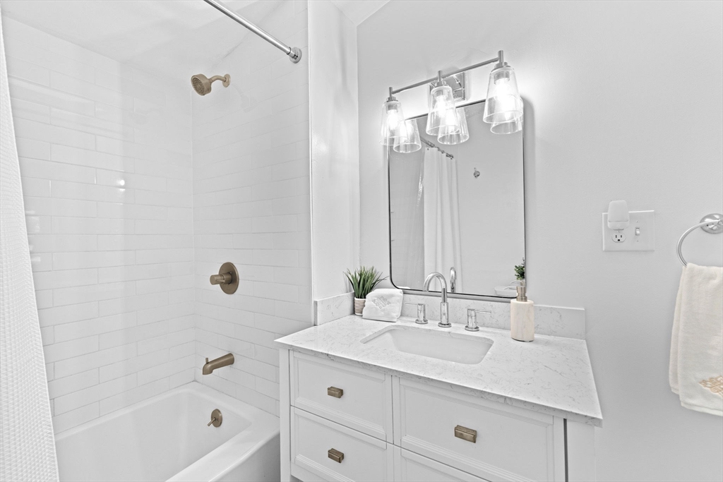 983 Webster Street Hanover, MA 02339 - Photo 24 of 41 a bathroom with a granite countertop sink a mirror and a bathtub