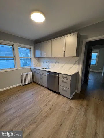 a kitchen with stainless steel appliances granite countertop a sink a stove and a wooden floors