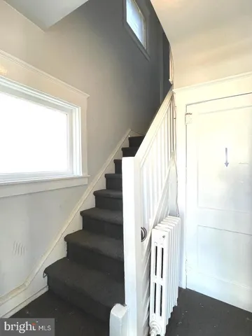 a view of staircase with wooden floor and white walls