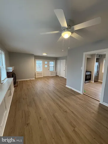 a view of an empty room and window and wooden floor