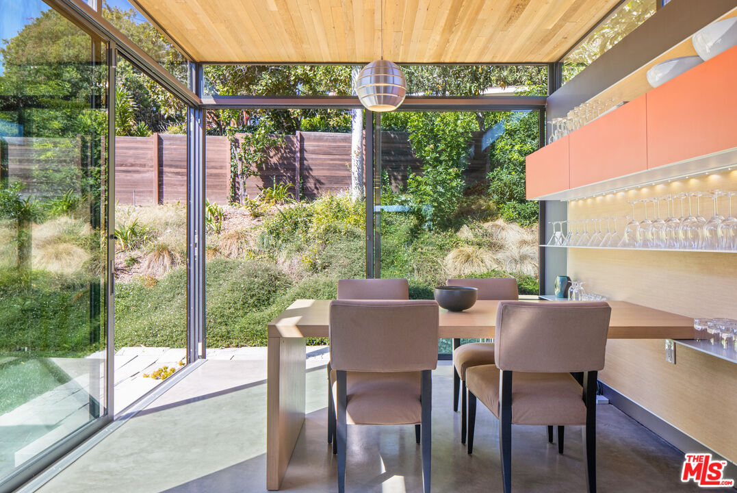 12321 Rochedale Lane Los Angeles, CA 90049 - Photo 22 of 46 a view of a patio with a table chairs and a backyard