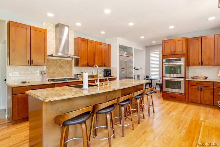 14532 Inca Court Westminster, CO 80023 - Photo 12 of 35 a large kitchen with kitchen island a large counter top space a sink stainless steel appliances and cabinets