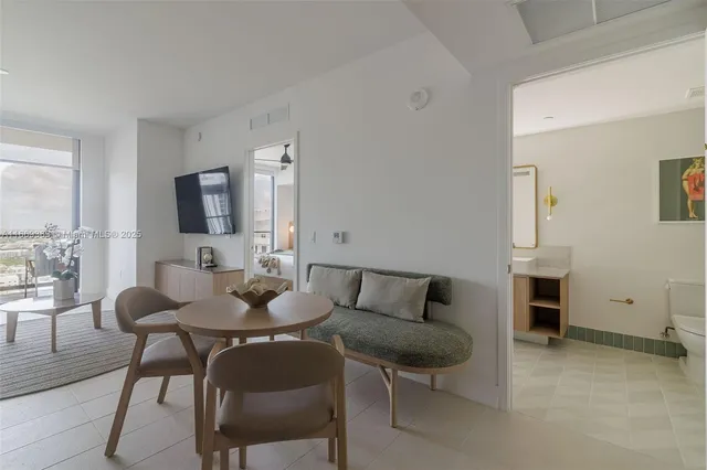 a living room with furniture a flat screen tv and a large window