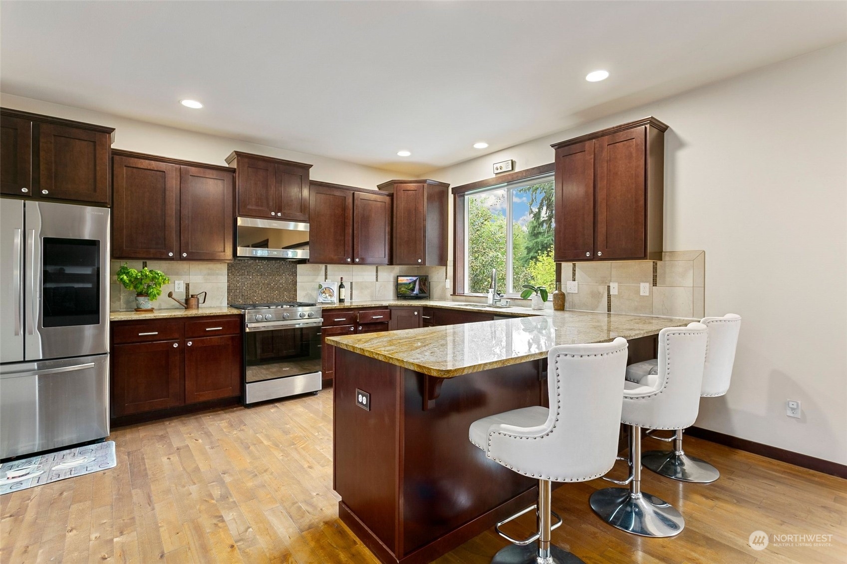 408 171st Street Southeast Bothell, WA 98012 - Photo 6 of 31 a kitchen with kitchen island granite countertop stainless steel appliances a sink a stove a refrigerator cabinets and dining table
