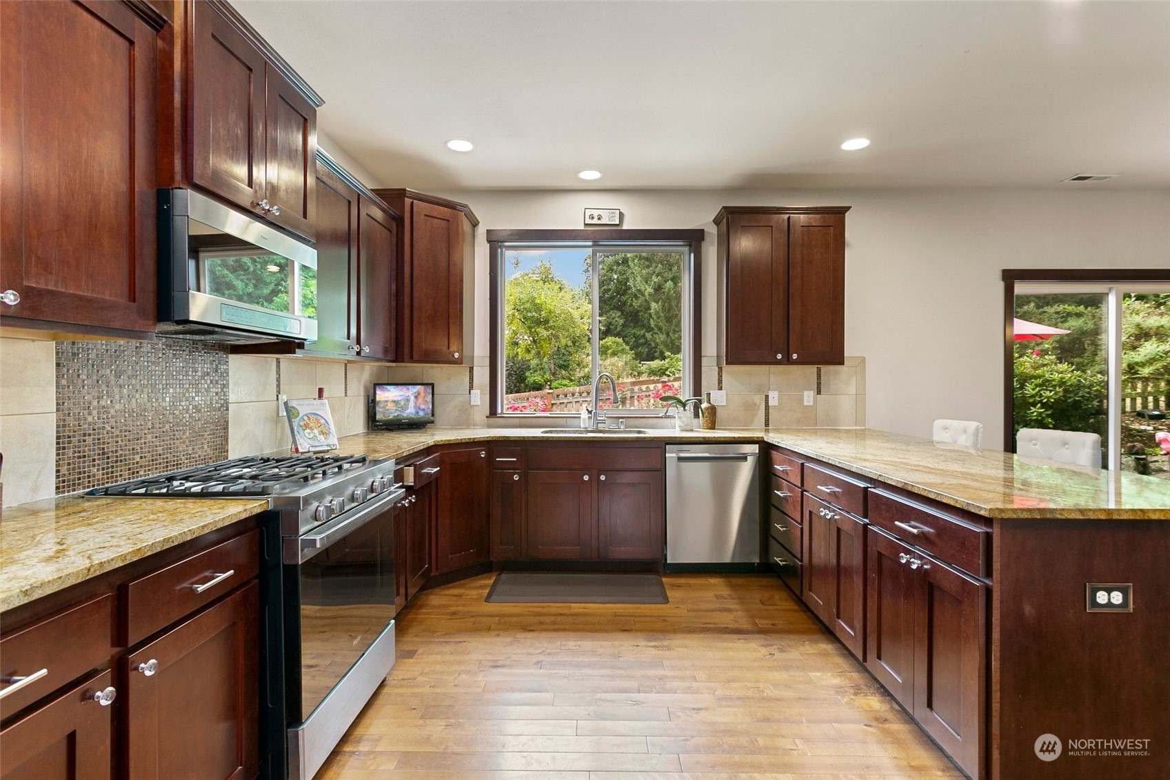 408 171st Street Southeast Bothell, WA 98012 - Photo 8 of 31 a kitchen with stainless steel appliances granite countertop wooden cabinets a sink and dishwasher a stove top oven with wooden floor