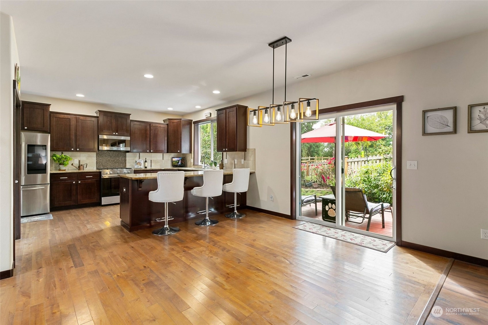 408 171st Street Southeast Bothell, WA 98012 - Photo 10 of 31 a open kitchen with stainless steel appliances kitchen island granite countertop a refrigerator oven a stove top oven and a dining table with wooden floor